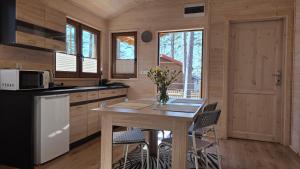a kitchen with a table and chairs in a cabin at LAZY DAYS domek nr 26 w Borsku in Borsk