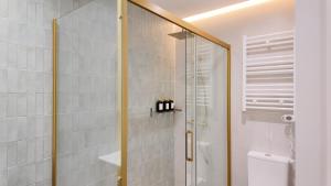 a shower with a glass door in a bathroom at The Eight Element Suites & Lofts in Madrid