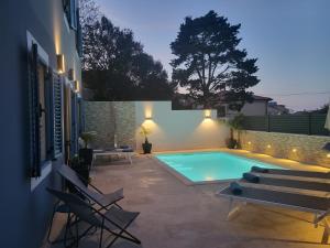 a swimming pool in a yard with chairs next to a building at Casa Solis Losinj in Mali Lošinj