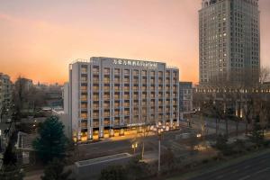 a large building in a city at sunset at Fairfield by Marriott Changchun Chaoyang in Changchun