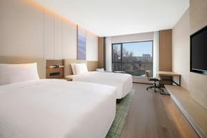 a hotel room with two beds and a flat screen tv at Fairfield by Marriott Changchun Chaoyang in Changchun
