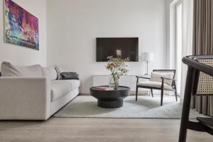 a white living room with a couch and a table at Atlantic Dependance Travemünde in Travemünde