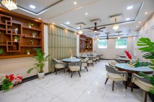 a restaurant with tables and chairs and plants at Aarchh Royale in Noida