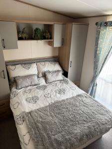 a bedroom with a bed with a blanket and a window at Tattershall Lakes 49 Larch View in Tattershall +29 photos