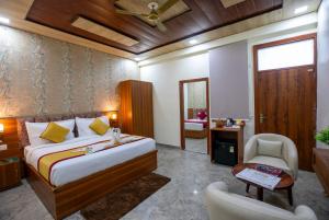 a bedroom with a bed and a desk and a chair at Aarchh Royale in Noida