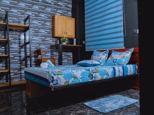 a bed in a room with a brick wall at Complexe Smile & Be in Yaoundé