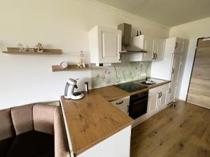 a kitchen with white cabinets and a wooden counter top at Seestern Strobl in Strobl