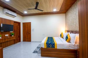 a bedroom with a bed and a flat screen tv at Aarchh Royale in Noida