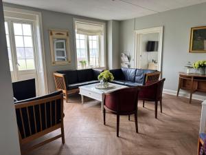a living room with a couch and a table at Forvalterboligen in Hadsund +6 photos