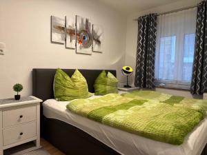 a bedroom with a bed with a green comforter at City Ferienwohnung Bayreuth in Bayreuth