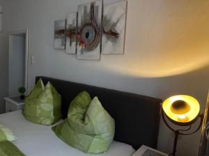 a bedroom with a bed with green pillows and a lamp at City Ferienwohnung Bayreuth in Bayreuth