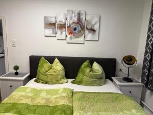a bedroom with a green bed with two green pillows at City Ferienwohnung Bayreuth in Bayreuth
