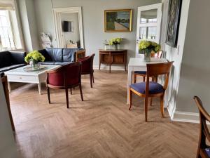 a living room with a couch and a table and chairs at Forvalterboligen in Hadsund