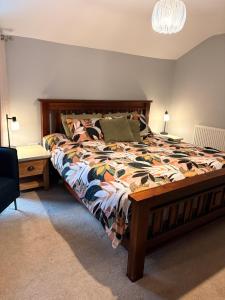 a bedroom with a large bed with a comforter at The willow tree inn in Pilsley