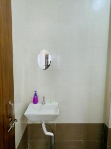 a white bathroom with a sink and a mirror at manoj lodge in Sangamner