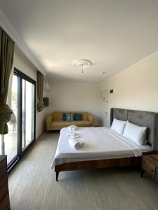 a bedroom with a large bed and a couch at Ayvalik Bir Tebessum in Ayvalık