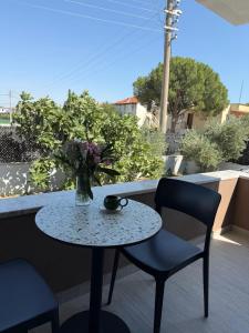 a table and chairs and a vase of flowers on a patio at Ayvalik Bir Tebessum in Ayvalık