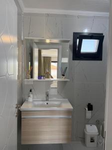 a bathroom with a sink and a mirror at Ayvalik Bir Tebessum in Ayvalık