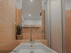 a bathroom with a white sink and a mirror at FeWo Sonnenschein mit Pool & Balkon in Horumersiel +19 photos