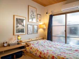 a bedroom with a bed and a window at Guesthouse Nagonde in Kanazawa
