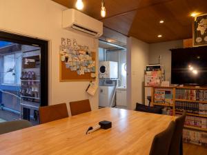 a room with a table in a library with a television at Guesthouse Nagonde in Kanazawa