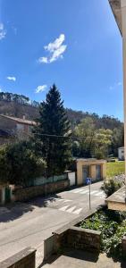 a parking lot with a tree and a street at Coeur Cevennes in La GrandʼCombe +12 photos