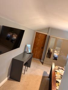a room with a desk and a bed and a mirror at The willow tree inn in Pilsley