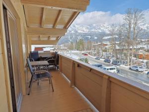 a balcony with a table and chairs and a view of the mountains at Pension Mirabelle in Ellmau