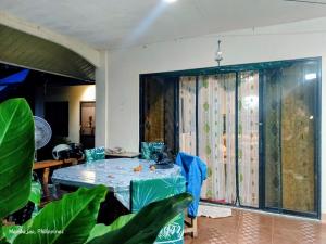 a dining room with a table and a large window at Camigs Vacation House in Mambajao +30 photos