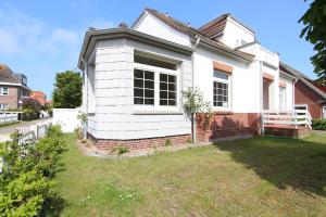 a white house with a lawn in front of it at Langeoog entspannt in Langeoog +11 photos