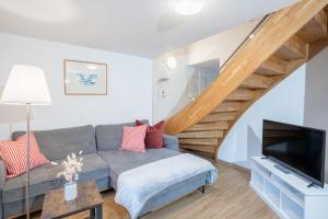a living room with a couch and a tv at Chalet zum See in Bregenz