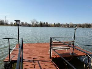 a wooden dock with a bench on the water at Rsd-Tass vendéghàz in Tass