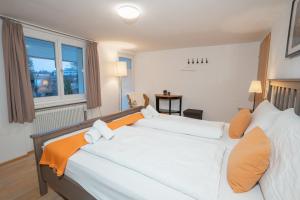 a bedroom with a large white bed with orange pillows at Chalet zum See in Bregenz