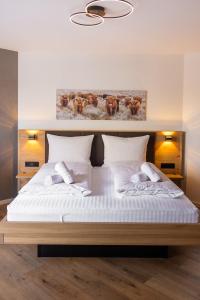 a bedroom with a large white bed with two pillows at Alfredo Hotel in Eppingen +45 photos