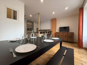 a bathroom with a black counter with two sinks and wine glasses at Maison au cœur d’Orgelet in Orgelet