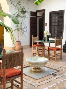 a living room with a table and chairs and a fountain at Riad Dar Balthazar in Marrakesh