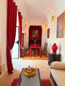 a living room with red curtains and a red table at Riad Dar Balthazar in Marrakesh