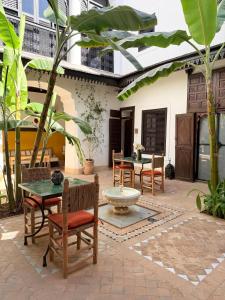 a patio with a table and chairs and a fountain at Riad Dar Balthazar in Marrakesh