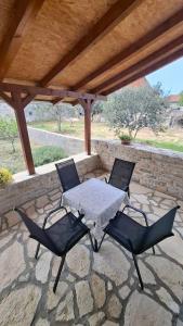 a patio with a table and chairs on a stone patio at Apartmani Dejan in Skradin