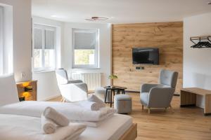 a bedroom with two beds and two chairs and a television at Alfredo Hotel in Eppingen