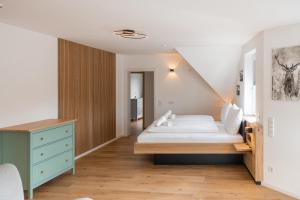 a bedroom with a bed and a blue dresser at Alfredo Hotel in Eppingen