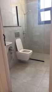 a bathroom with a toilet and a glass shower at شقة تراحيب الشمال للضيافة in Riyadh