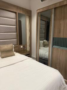 a bedroom with a large white bed and a mirror at شقة تراحيب الشمال للضيافة in Riyadh