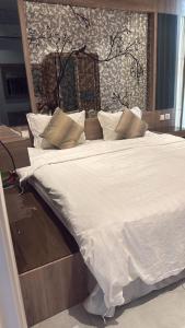 a large bed with white sheets and pillows at شقة تراحيب الشمال للضيافة in Riyadh