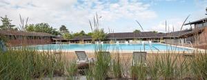 a swimming pool with chairs in front of a building at Kysthusene in Gilleleje