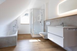 a bathroom with a sink and a toilet and a bath tub at Alfredo Hotel in Eppingen