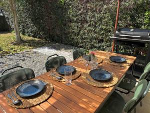 a wooden table with plates and glasses on it at 館山ガーデンヴィラ 宮城ハウス - 平屋一棟貸し 屋根付きBBQ ペットok in Tateyama