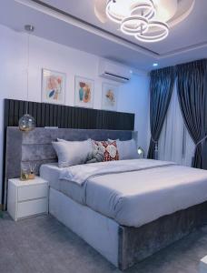 a bedroom with a large bed in a room with blue walls at Harmony Villa in Nnewi