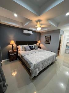 a bedroom with a bed and two lamps and a ceiling at Harmony Villa in Nnewi