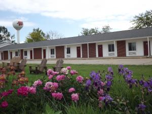 a building with chairs and flowers in the yard at Crest Country Inn in Williamsburg